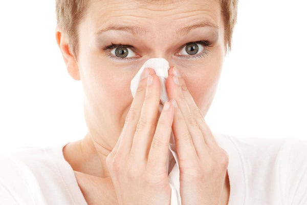 short red hair woman blowing her nose